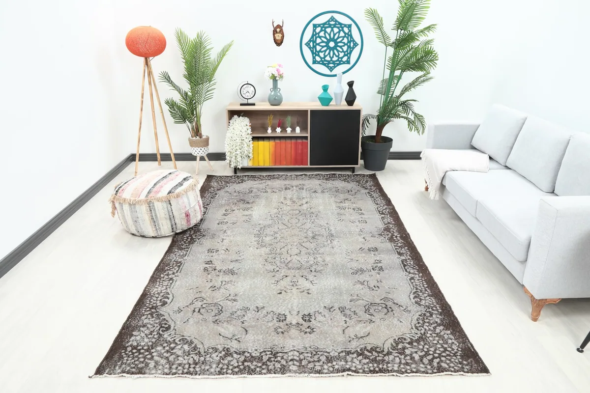 Vintage gray and brown rug placed in a modern living room setting with a light gray sofa