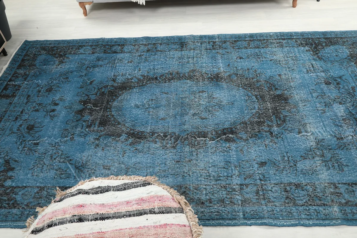 View of the vintage blue rug from another angle, highlighting its size and design in the living space