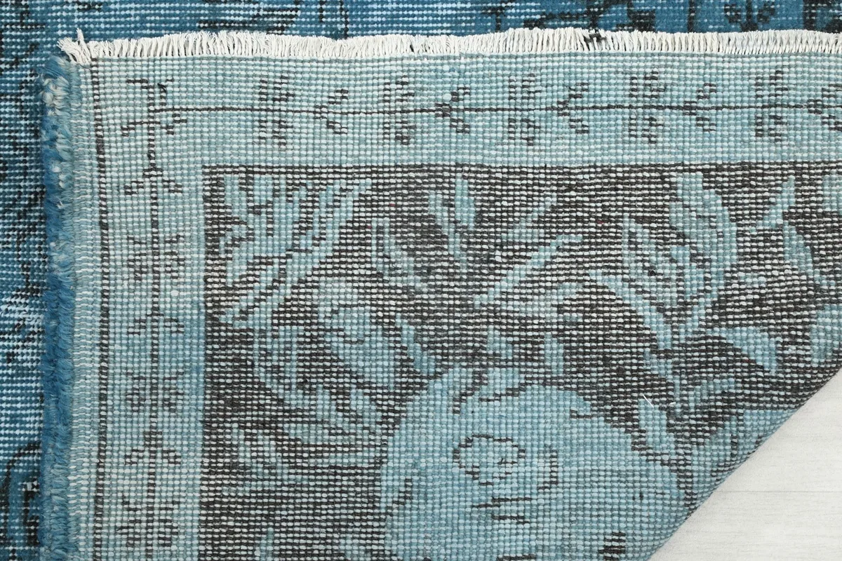 Close-up of the rug's edge, showing the short fringe and the details of the border design