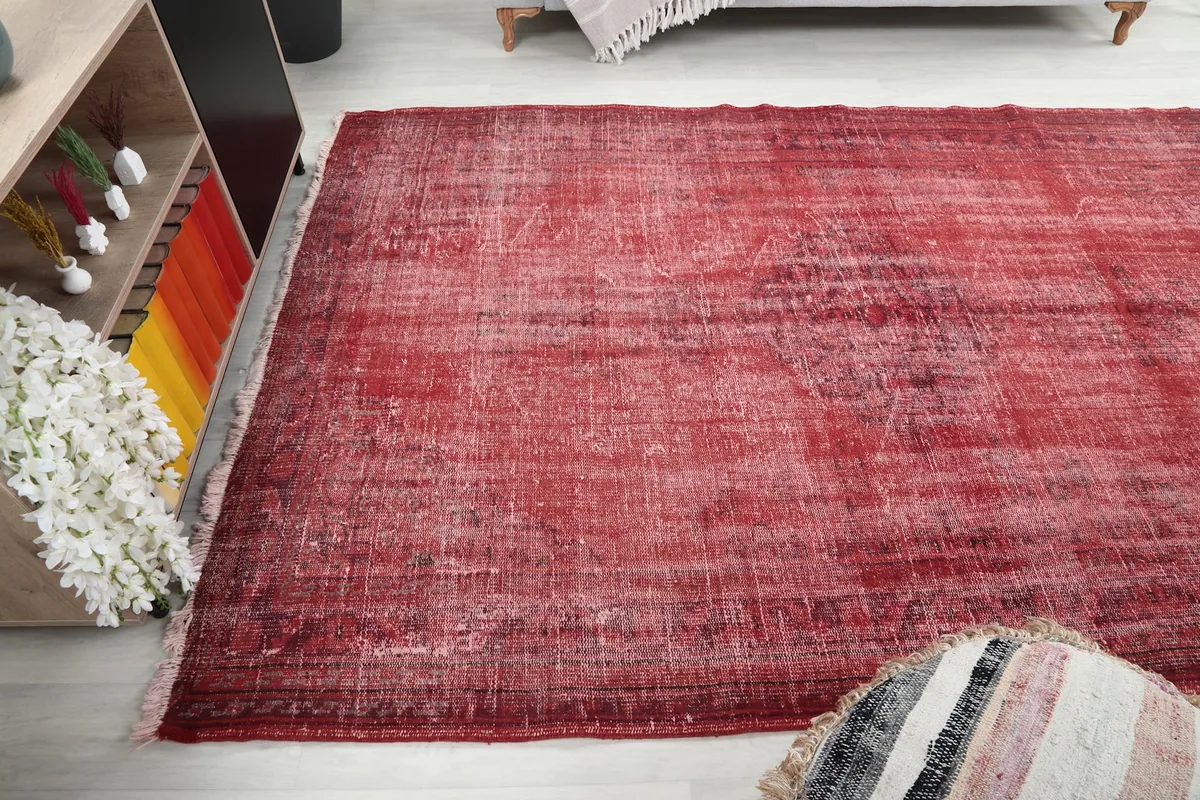 Wide shot of the red distressed rug in a contemporary living space, viewed from an angle