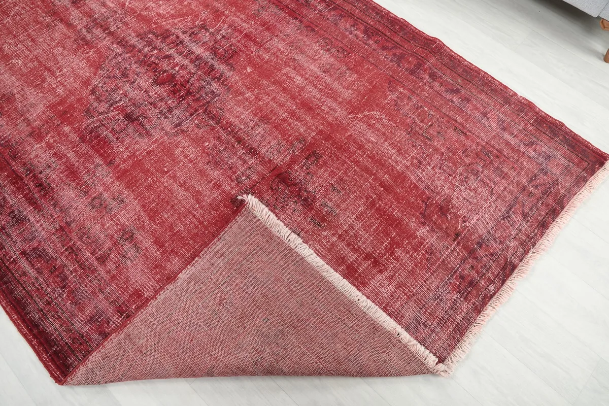 Folded corner of the rug revealing the wool pile on the front and the cotton foundation on the back