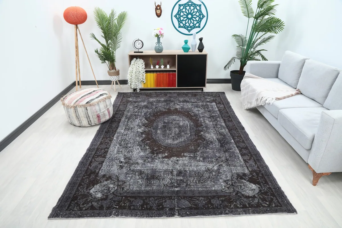 Vintage charcoal rug centered in a modern living room setting with a light sofa