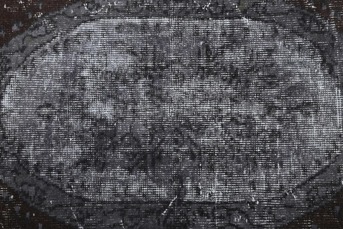 Close-up of the central medallion, showing the faded wool pile texture and muted colors