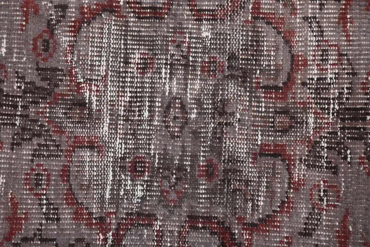 Extreme close-up of the rug's low wool pile, revealing the hand-knotted texture and color variations