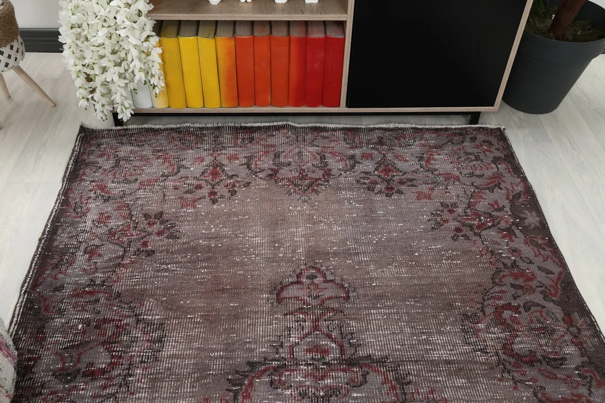 Overhead view of the top half of the rug, highlighting the distressed brown field and intricate patterns