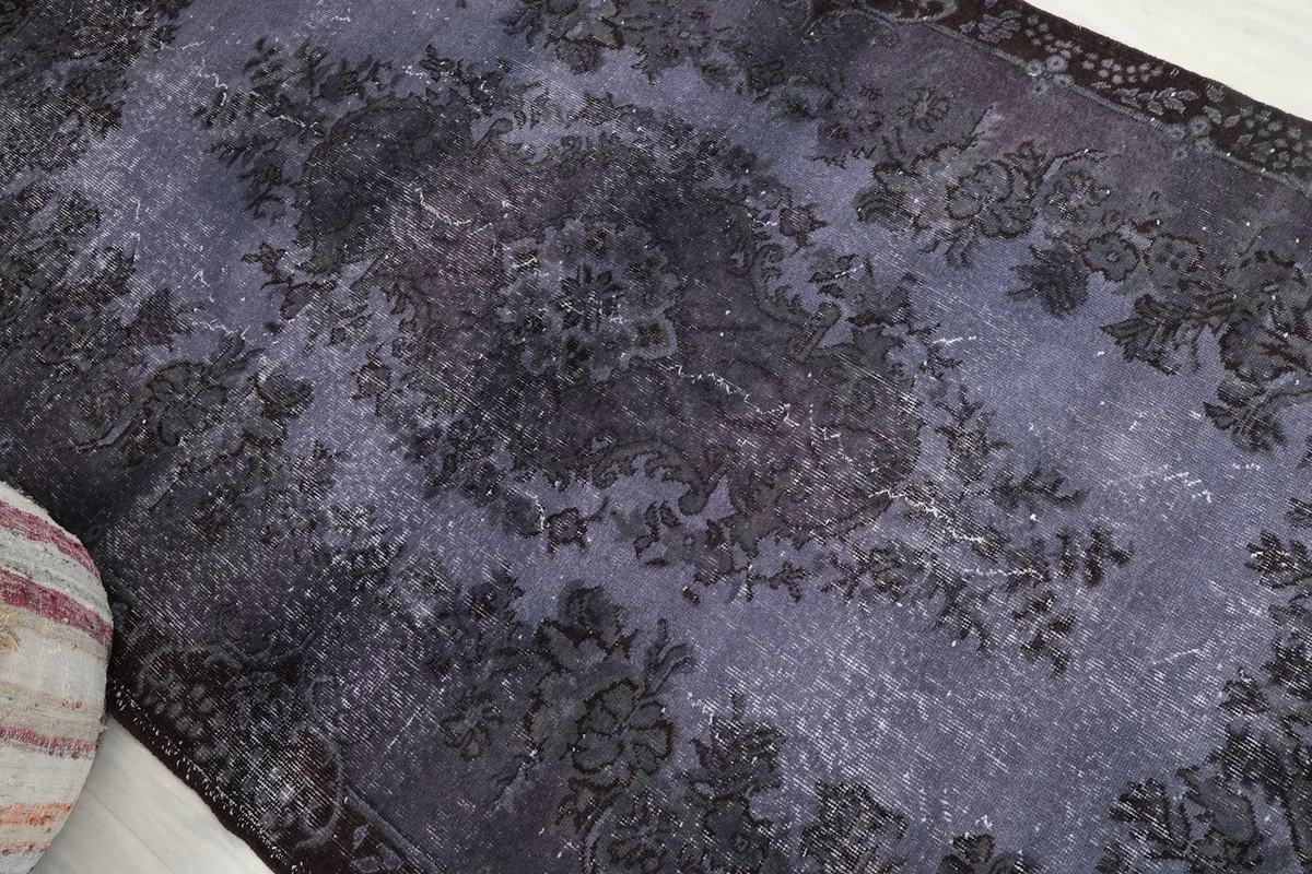 Angled view highlighting the distressed texture and floral motifs of the rug