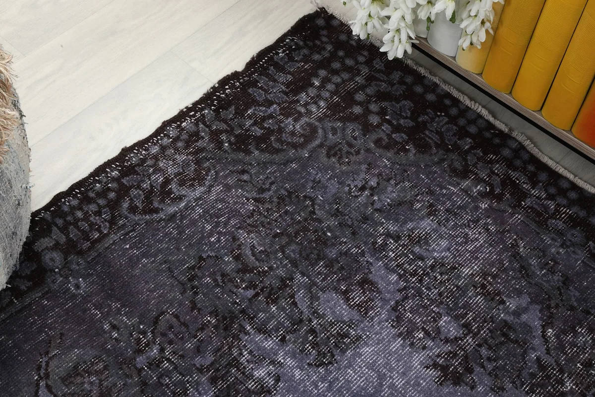 Close-up of the charcoal border with intricate patterns and faded purple tones