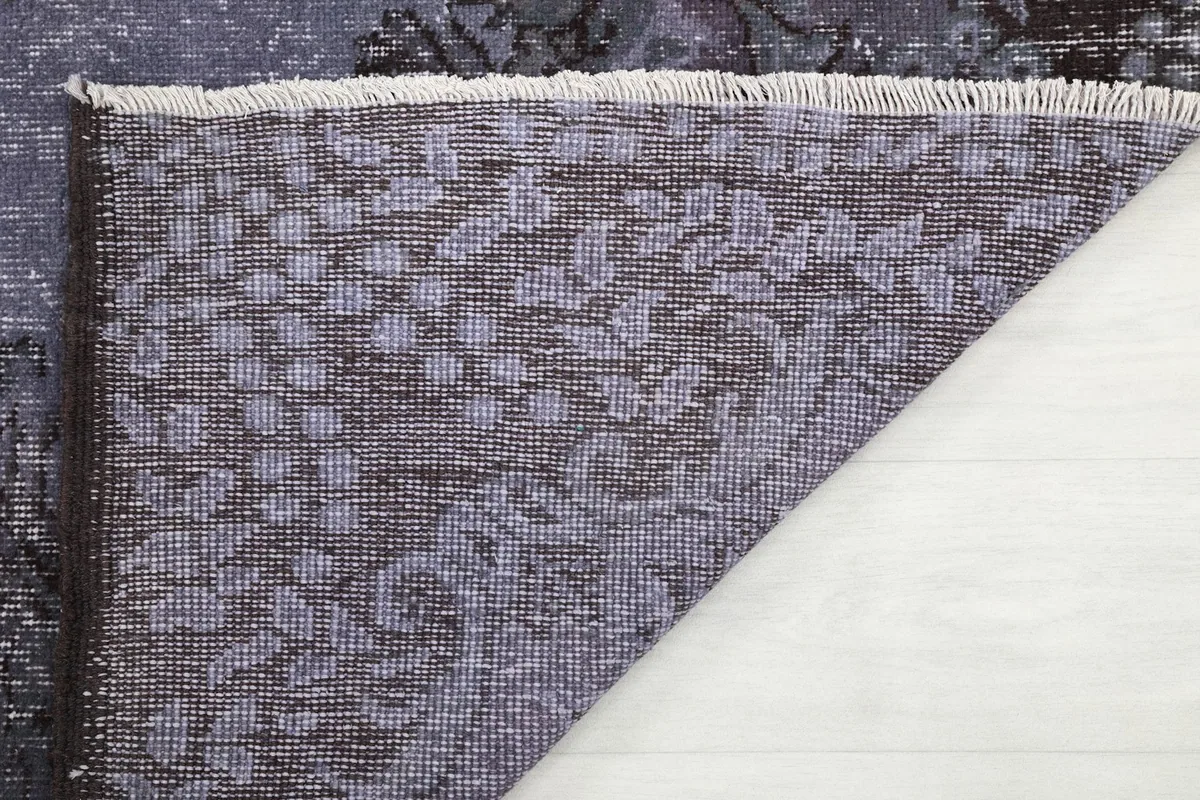 View of the back of the rug, showcasing the cotton foundation and fringe