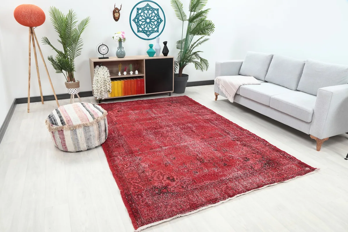 Angle view of the red rug in a room, highlighting its color and texture against a light floor.