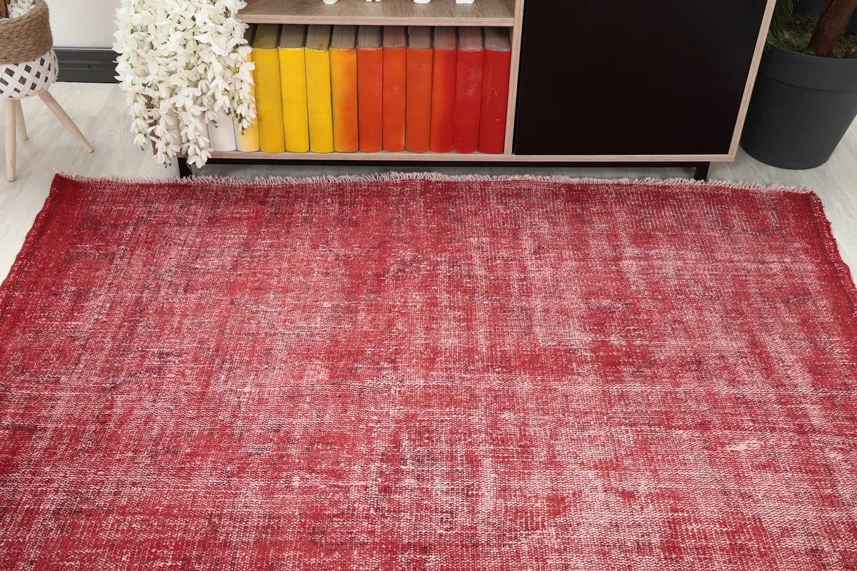 Overhead view of the red distressed vintage rug in a room, highlighting its full size and color.