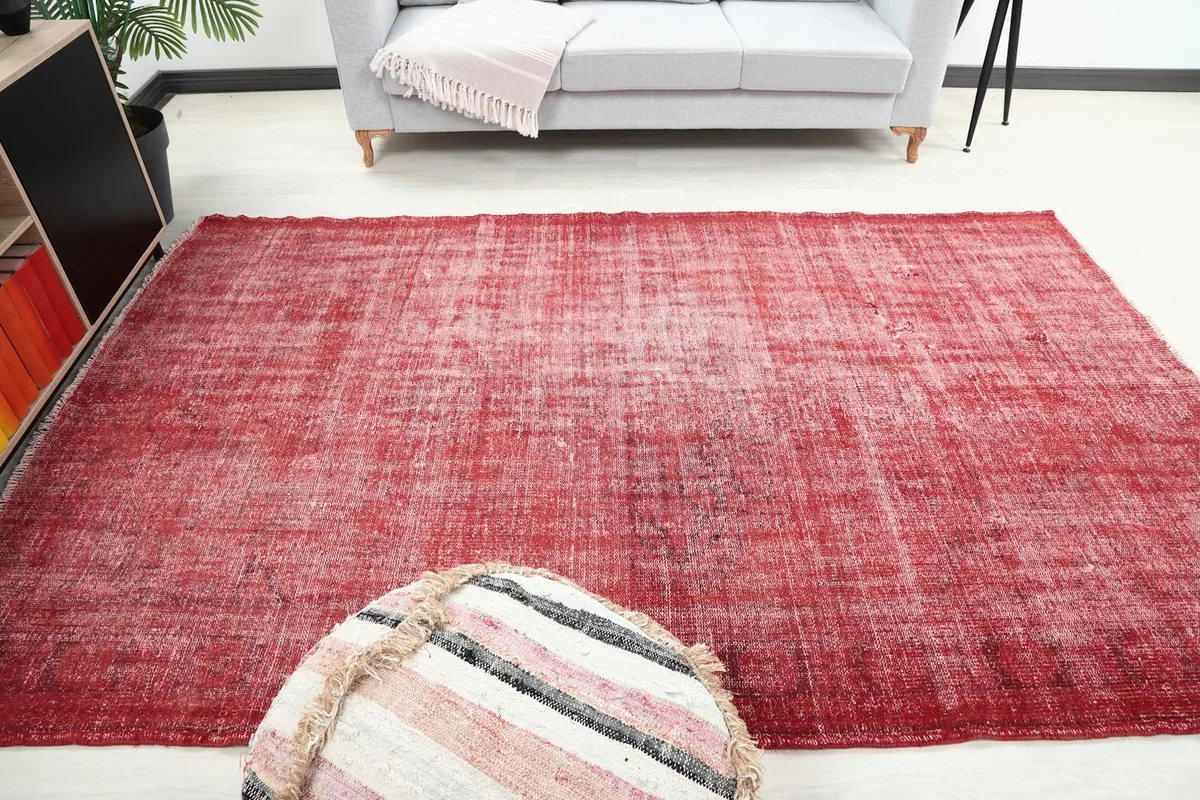Top-down view of the red distressed vintage rug, showcasing its rectangular shape and overall appearance in a room.