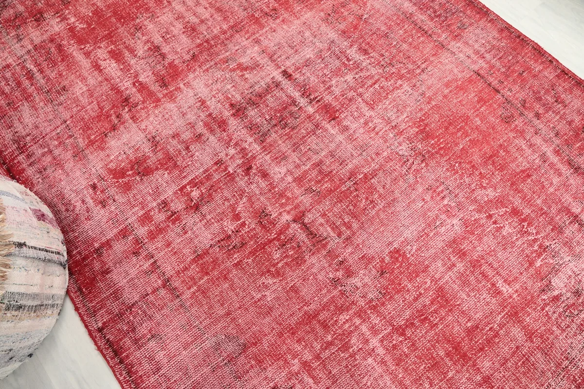 Angle view highlighting the worn, faded rose tones of the rug