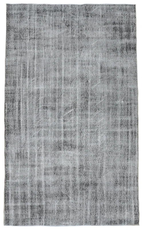 Full overhead view of the charcoal and gray faded vintage Anatolian rug on a white background.