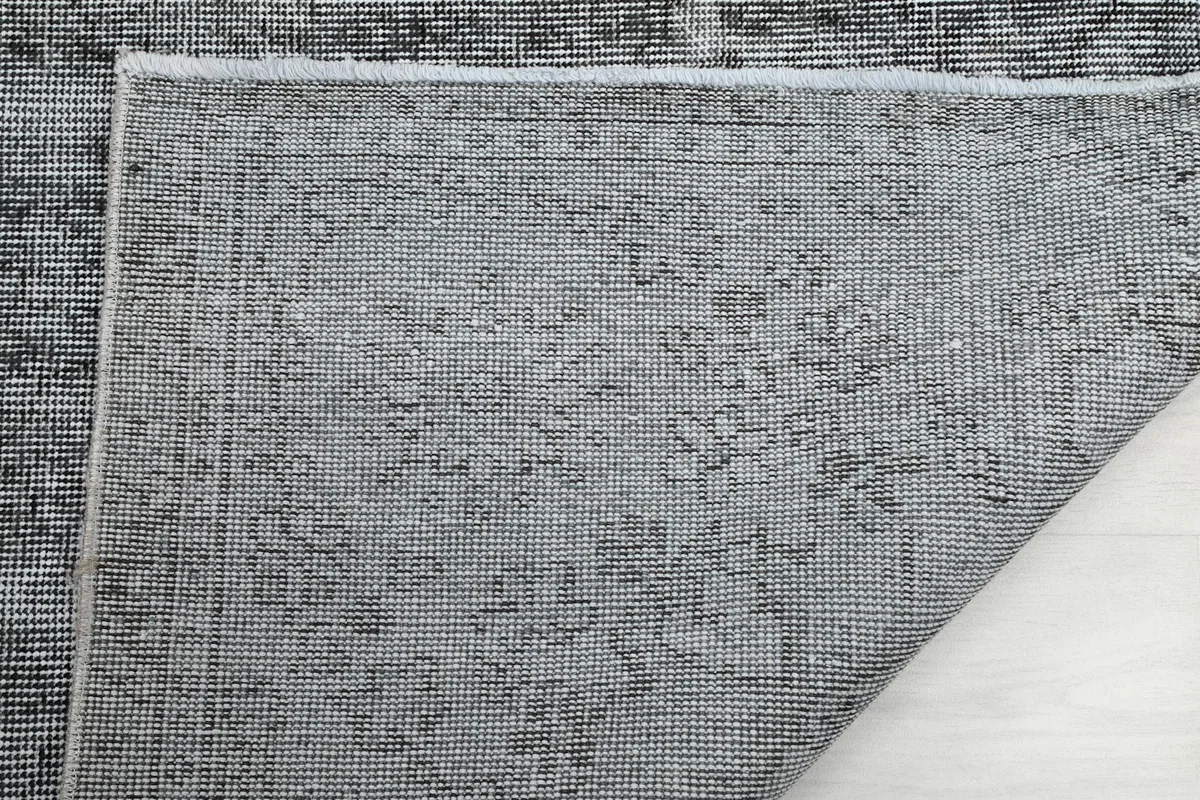 Detail of the rug's reverse side, showing the intricate knotting and sturdy cotton foundation.