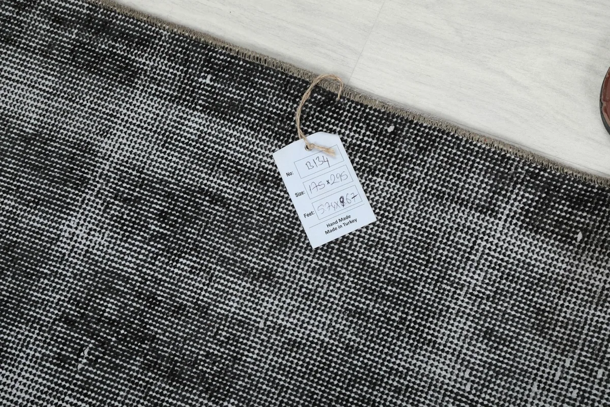 Rug corner with an attached tag displaying product information and origin details.