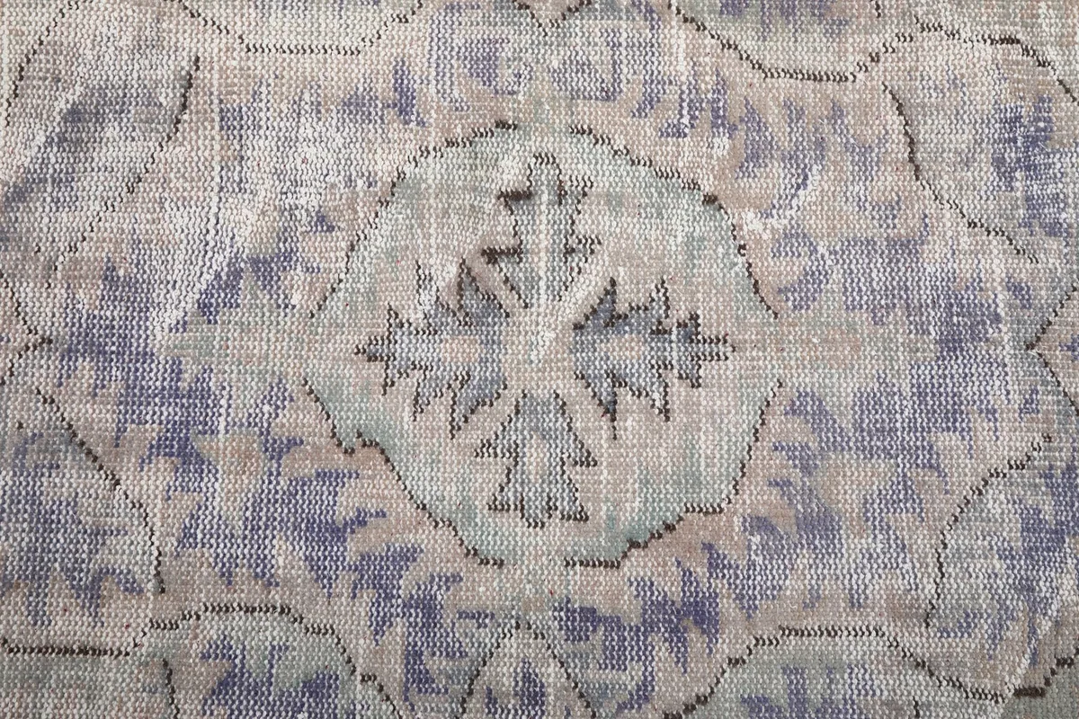 Detailed view of the faded wool pile and intricate patterns