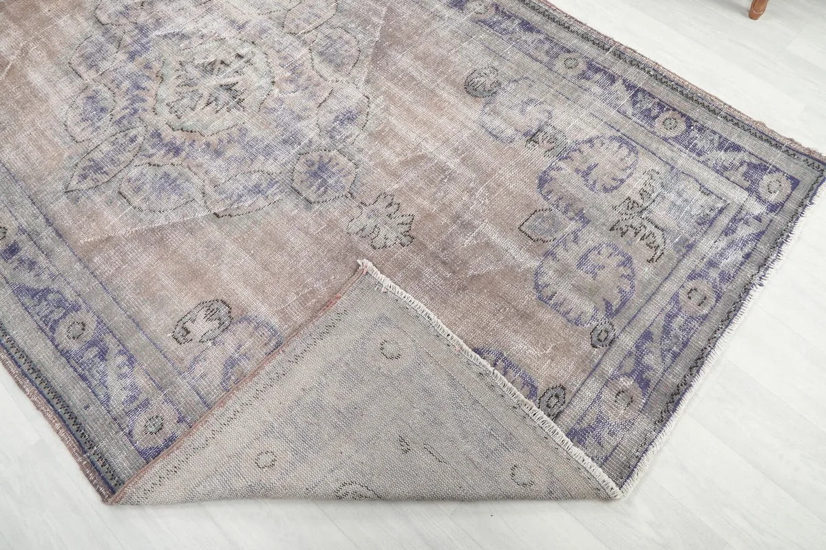 Corner of the rug folded back to reveal the cotton foundation