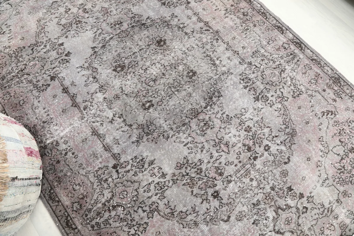 Overhead angle showing the distressed texture and intricate medallion design of the vintage wool rug.