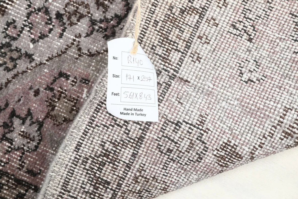 Detail of the rug's reverse side with a tag showing its size in centimeters and feet.