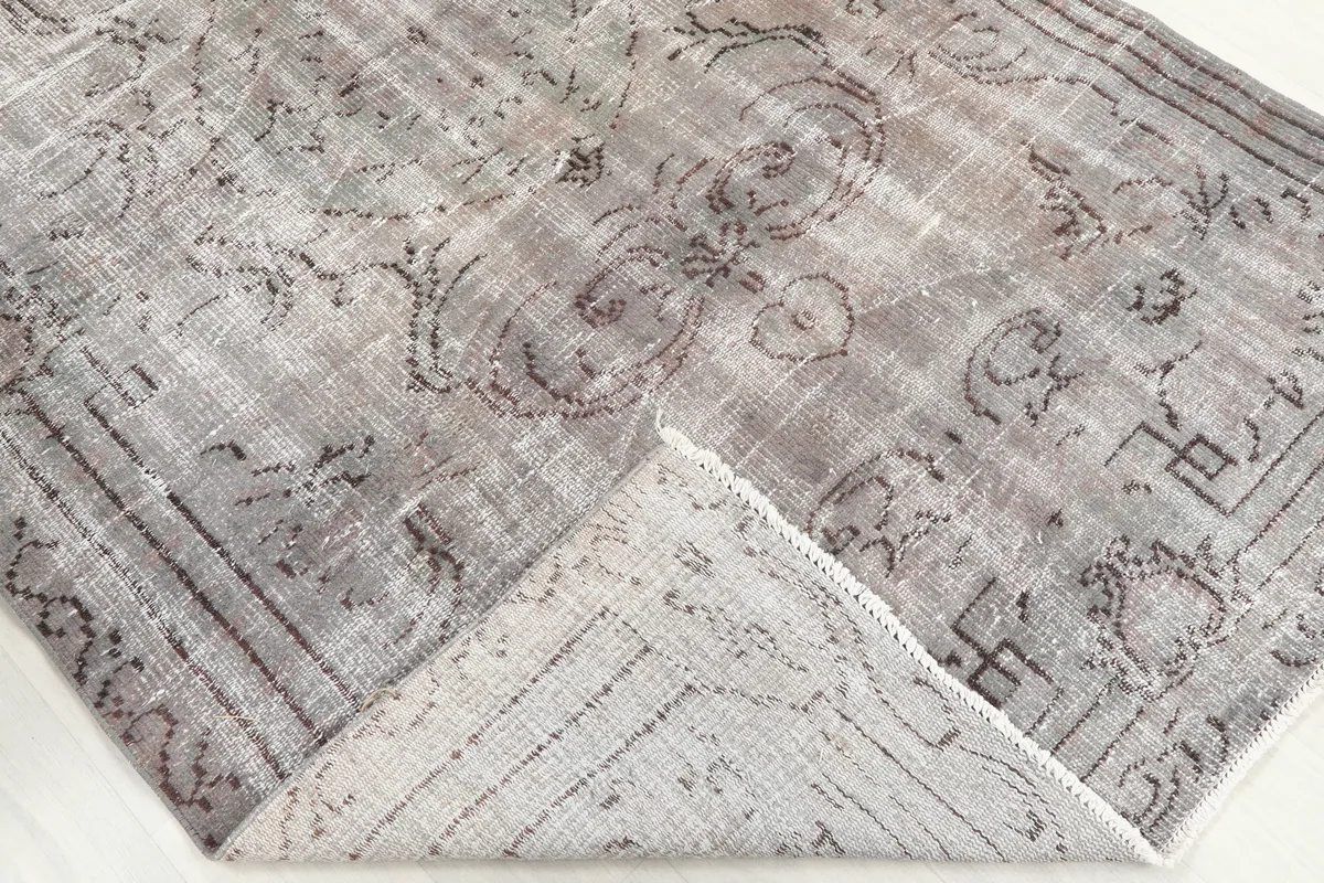 A folded corner of the Gray Medallion Anatolian Rug, showing the wool pile and cotton foundation.