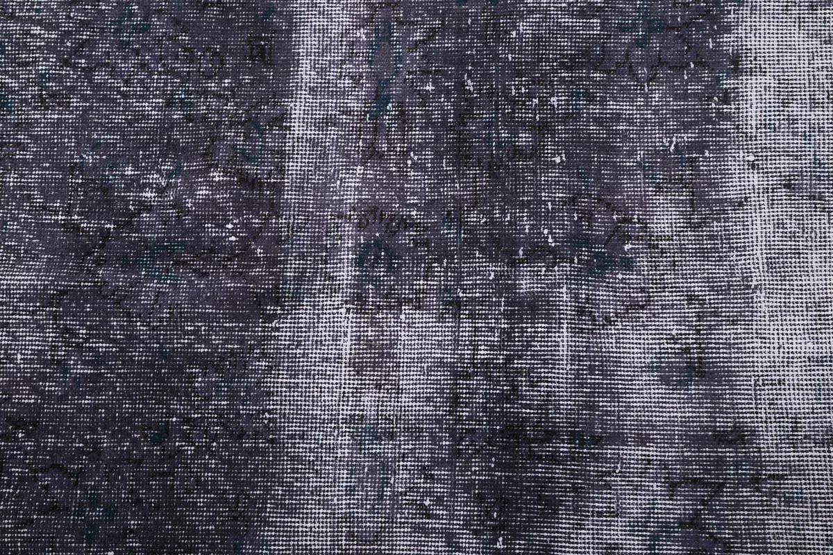 Close-up of the hand-knotted wool pile, revealing the varied charcoal and gray tones.