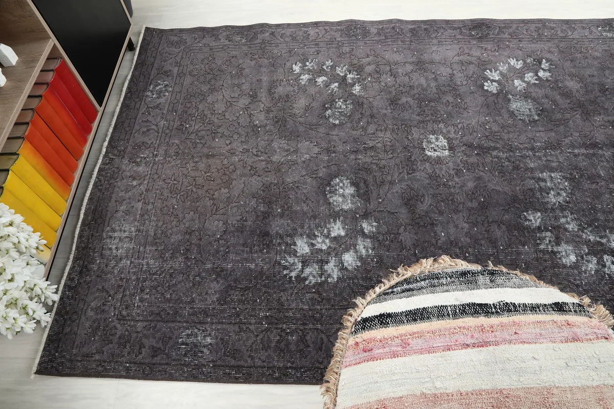 Wide angle shot of the charcoal rug, showing its placement in a room with a colorful bookshelf