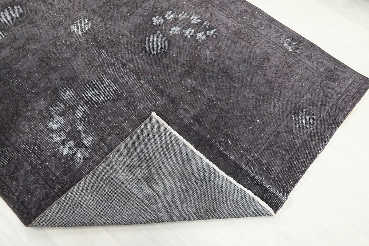 Corner of the rug folded back to reveal the cotton foundation and reverse side