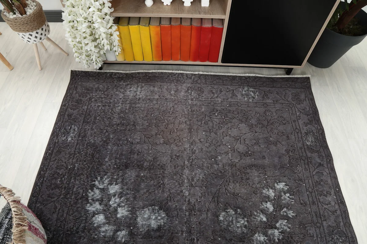 Overhead view of the charcoal rug, emphasizing its rectangular shape and faded patterns