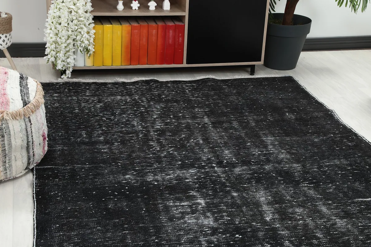 Close-up view of the charcoal rug's distressed surface and texture in a room setting