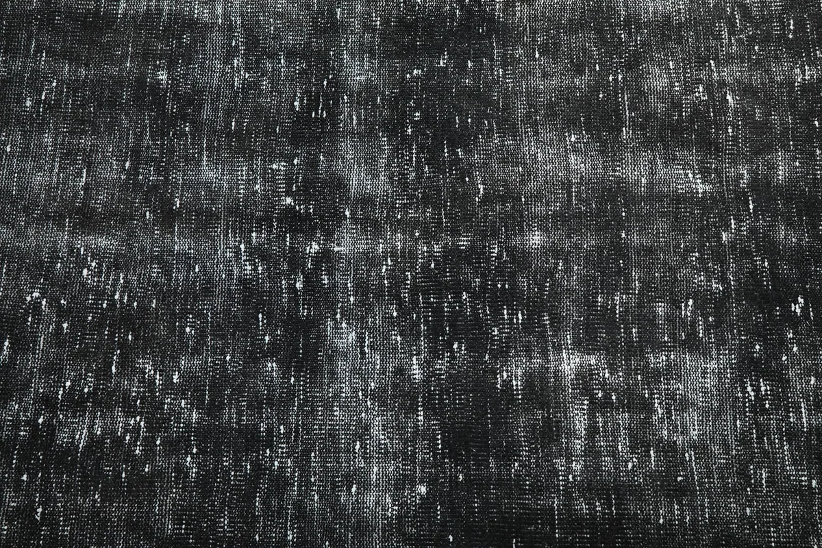 Close-up of the rug's low pile, showing individual knots and fiber variations