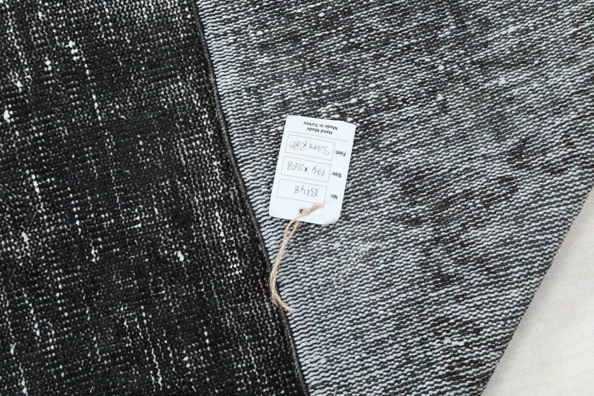 Rug corner with product tag, showing the reverse side and knotting detail