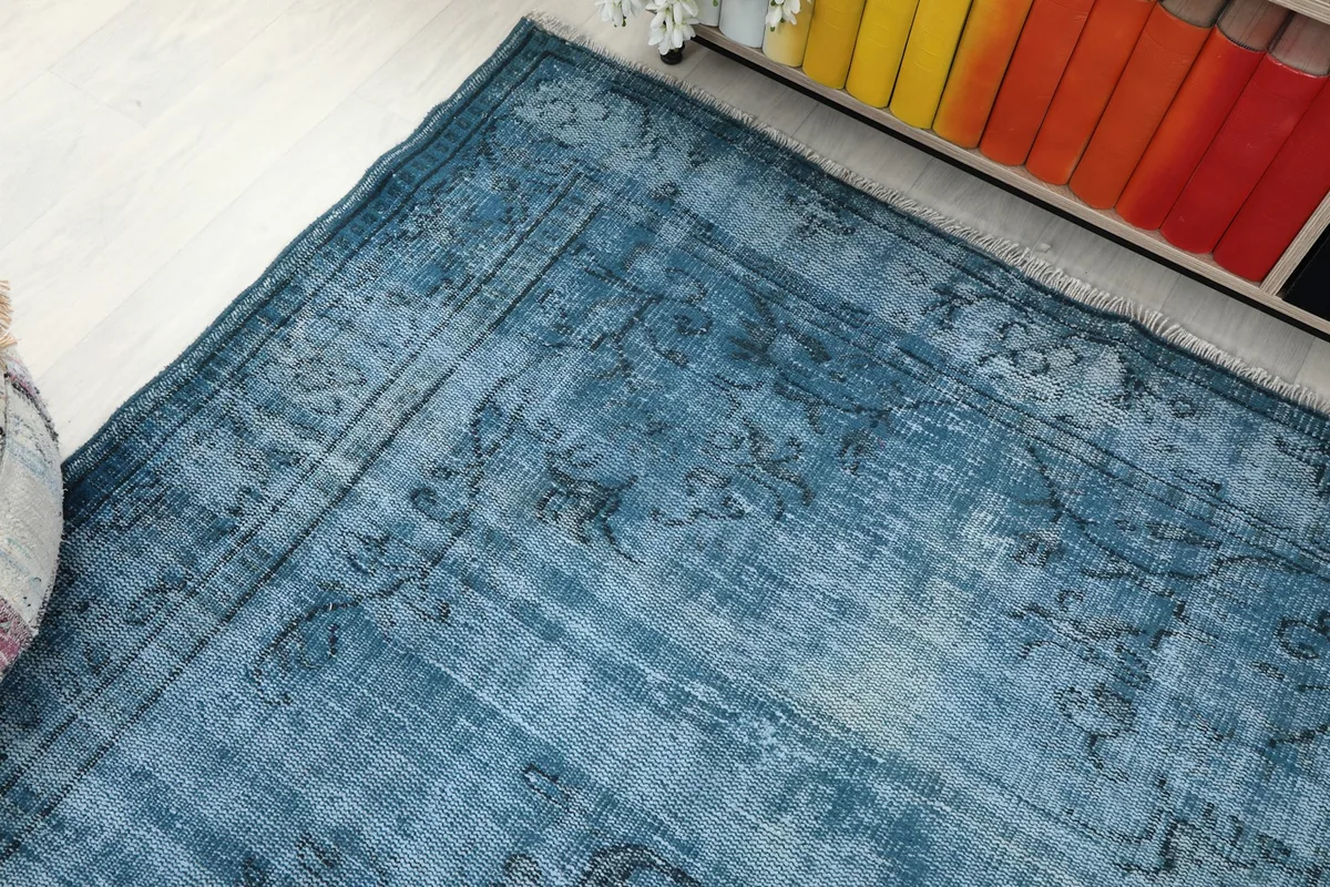 Corner view of the blue Anatolian rug, displaying its faded design and rich character