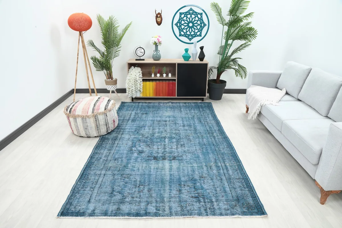 Vintage blue Anatolian rug in a modern living room setting with a light gray sofa