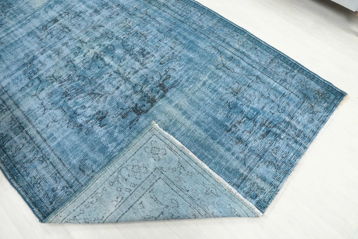 Folded corner revealing the cotton foundation and reverse side of the hand-knotted rug