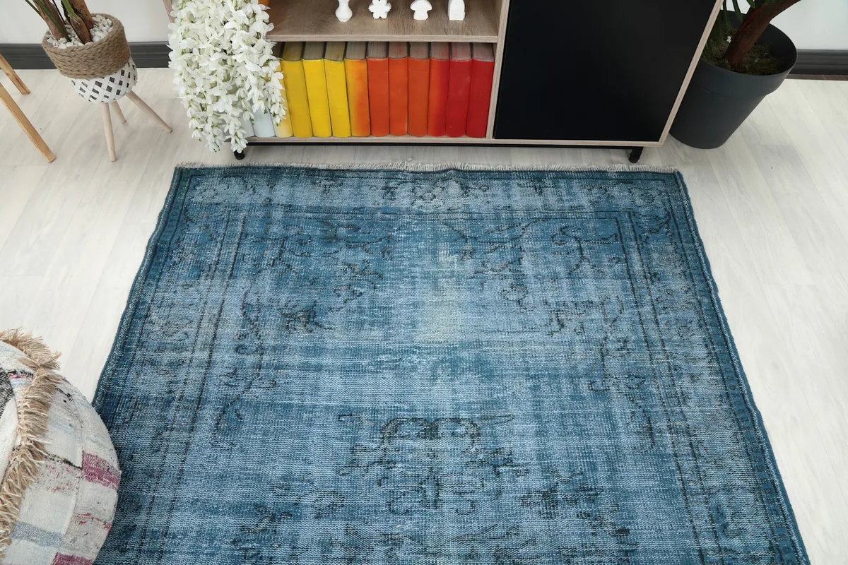 Overhead shot of the blue area rug, capturing its overall distressed appearance