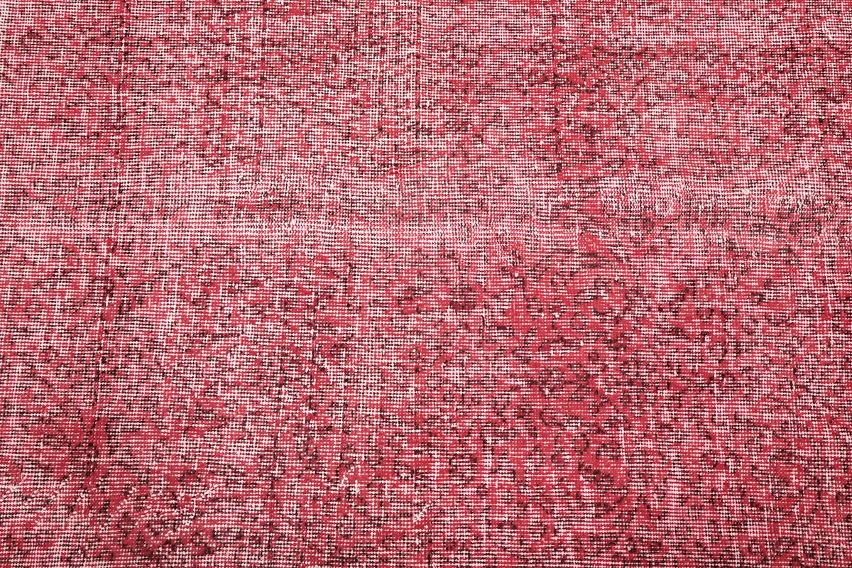 Macro shot of the low wool pile, showcasing the rose and cream color variations and wear