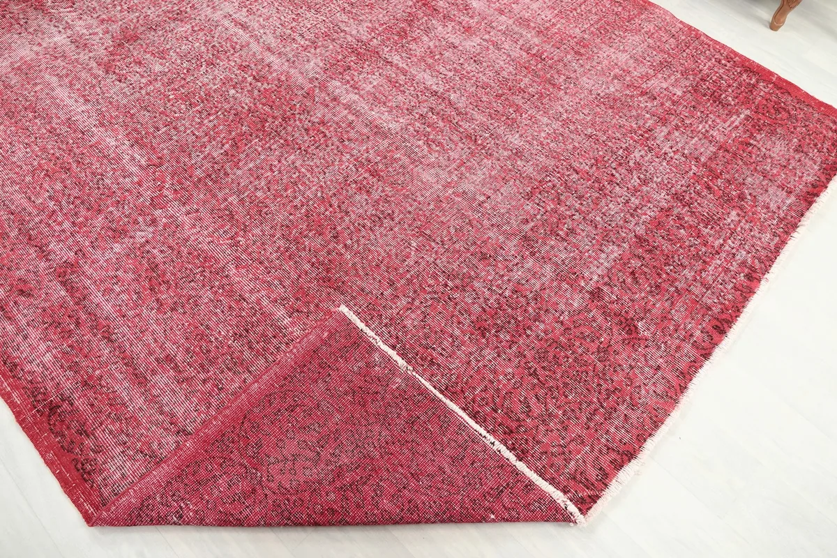 Corner of the rose rug folded back to reveal the cotton foundation and reverse side