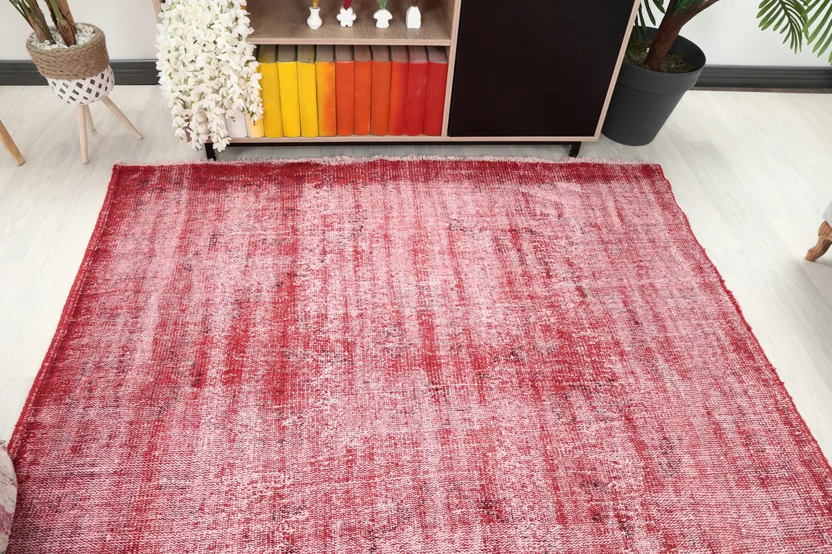 Overhead view of the red vintage rug in a living room, positioned in front of a console table.