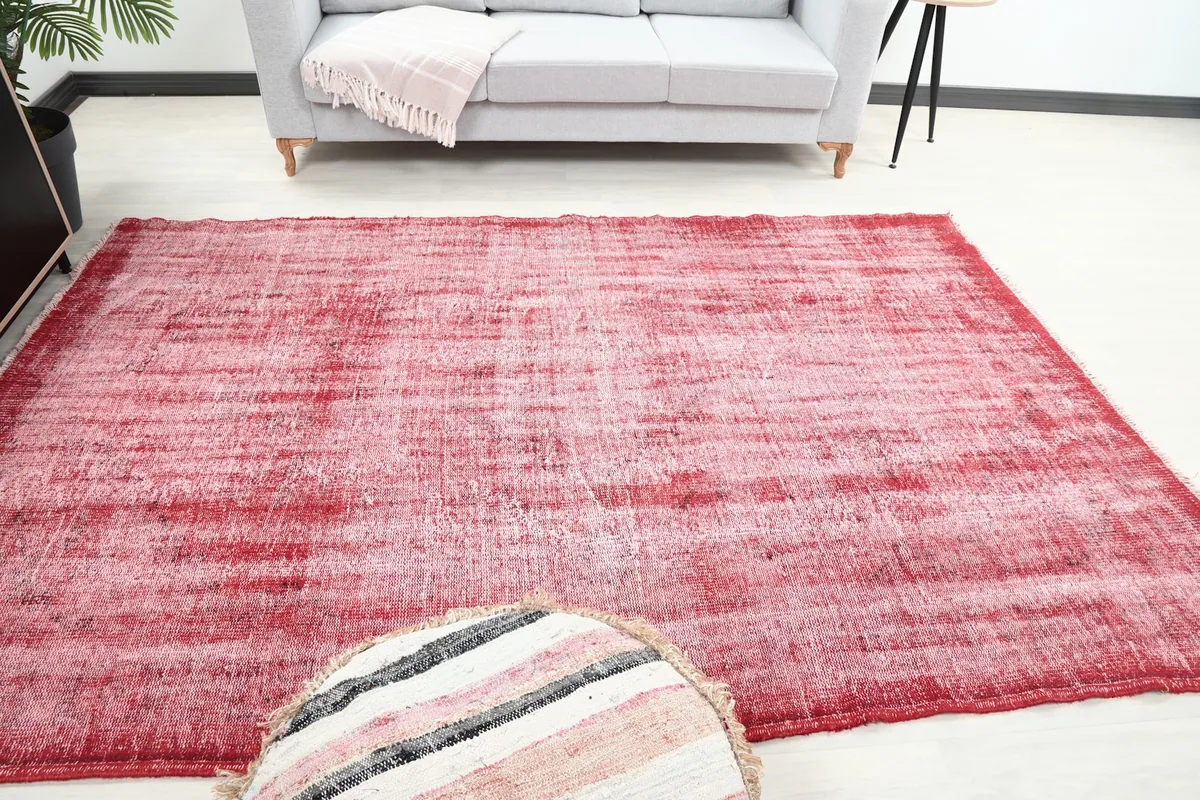 Straight-on view of the red and rose area rug in a room, showing its full dimensions relative to furniture.