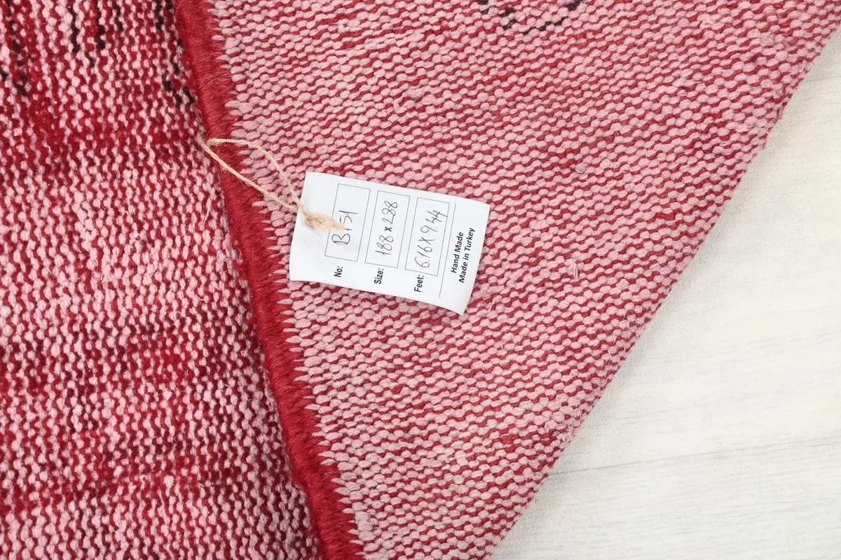 Close-up of the rug's reverse side with a tag, showing the intricate hand-knotted structure.