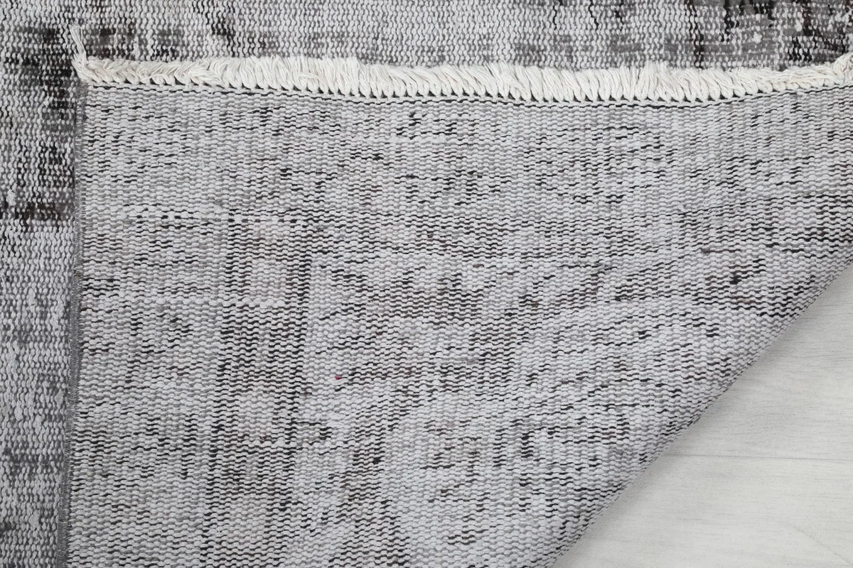 Close-up of the back of the hand-knotted rug, revealing the intricate weaving and foundation.