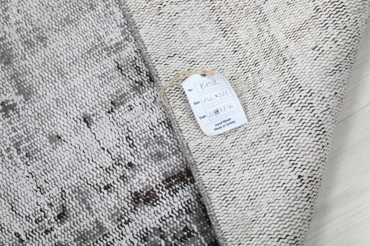 Detail of the rug's back with a product tag, showing its origin and material.