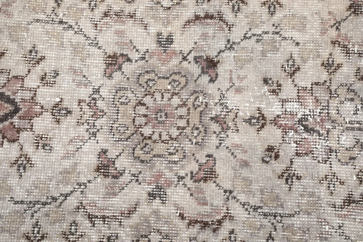 Macro detail of the hand-knotted wool pile, showing individual floral elements and colors