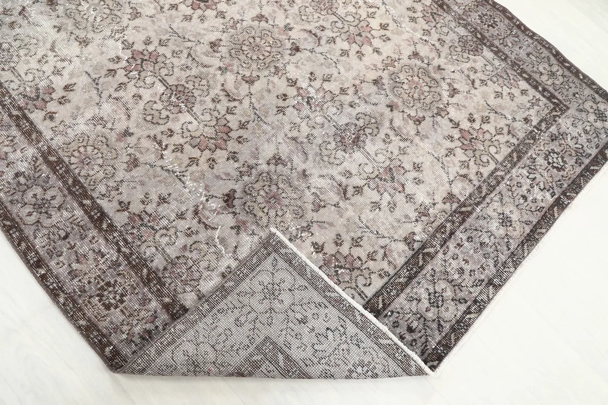 Corner of the rug folded back, revealing the reverse side of the hand-knotted construction
