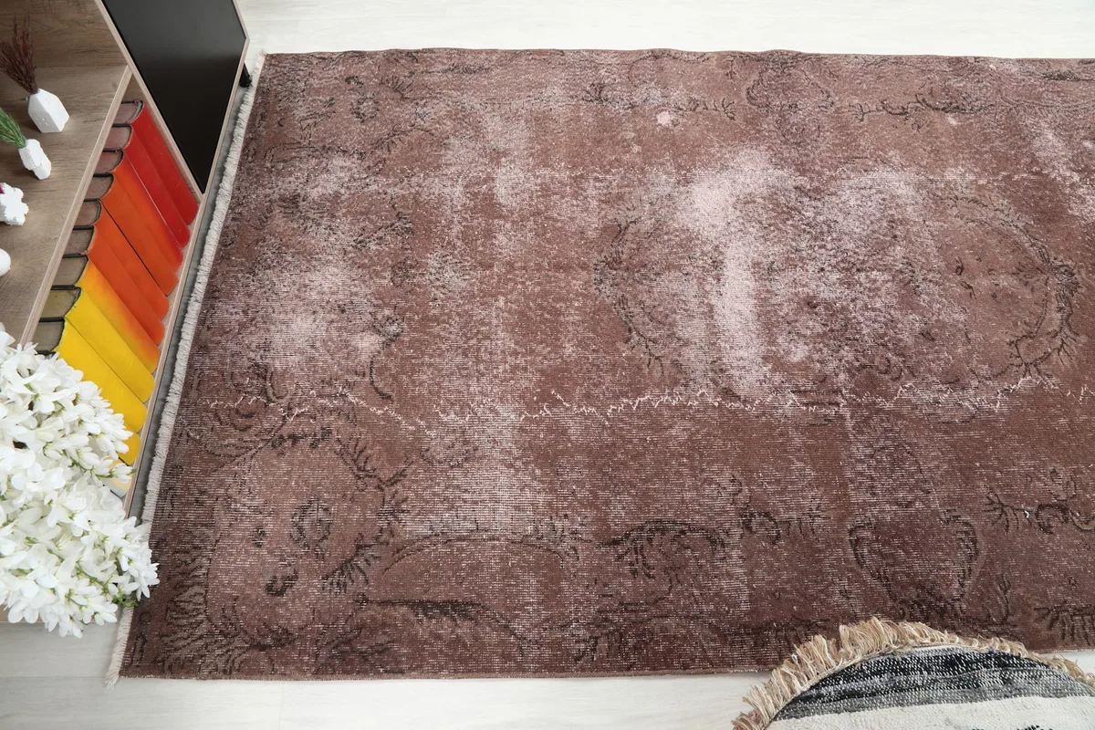 Angled view of the rust rug, showing its presence in a bright room setting