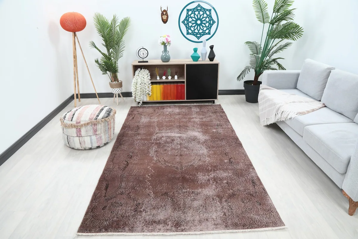 Rust vintage rug displayed in a modern living room setting with a light gray sofa