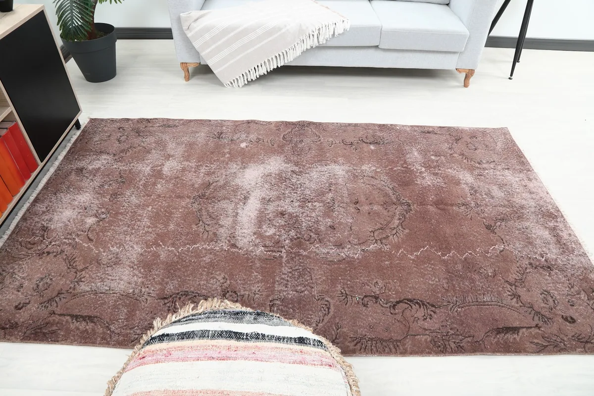 Rust area rug laid out in a living space, providing a warm foundation to the decor