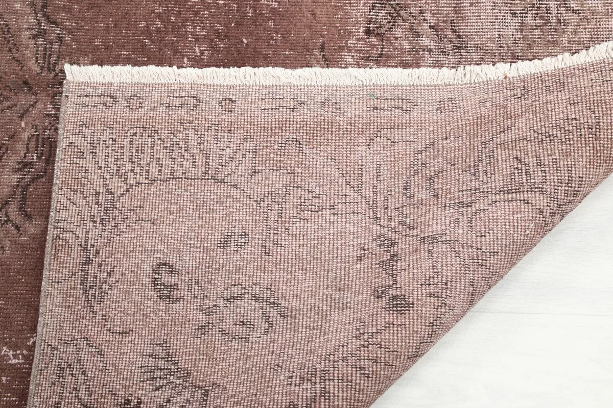 Close-up of the rug's back, showing the tight hand-knotted construction and fringe