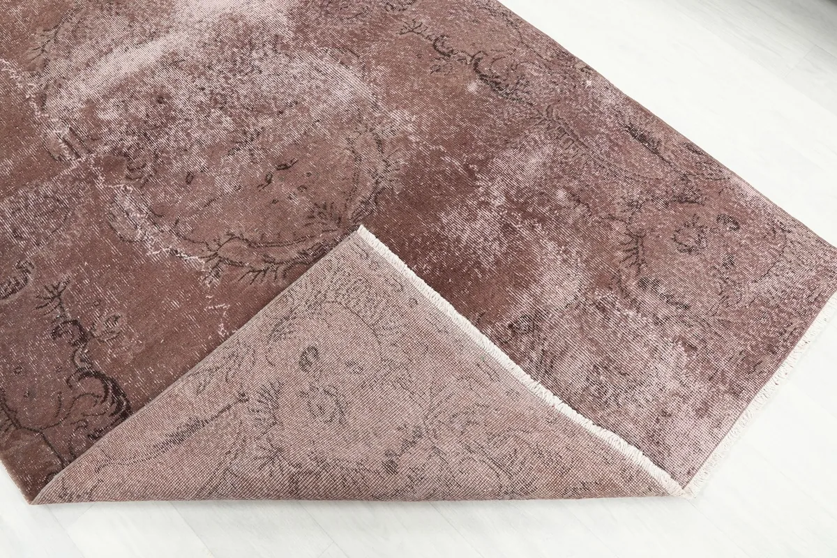 Folded corner of the rug, revealing the back of the hand-knotted wool pile on cotton foundation