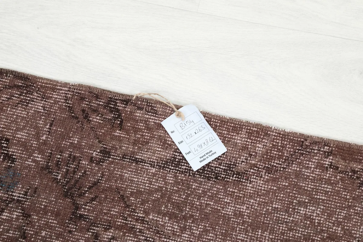Image showing the product tag on the rust vintage rug, indicating its origin and material